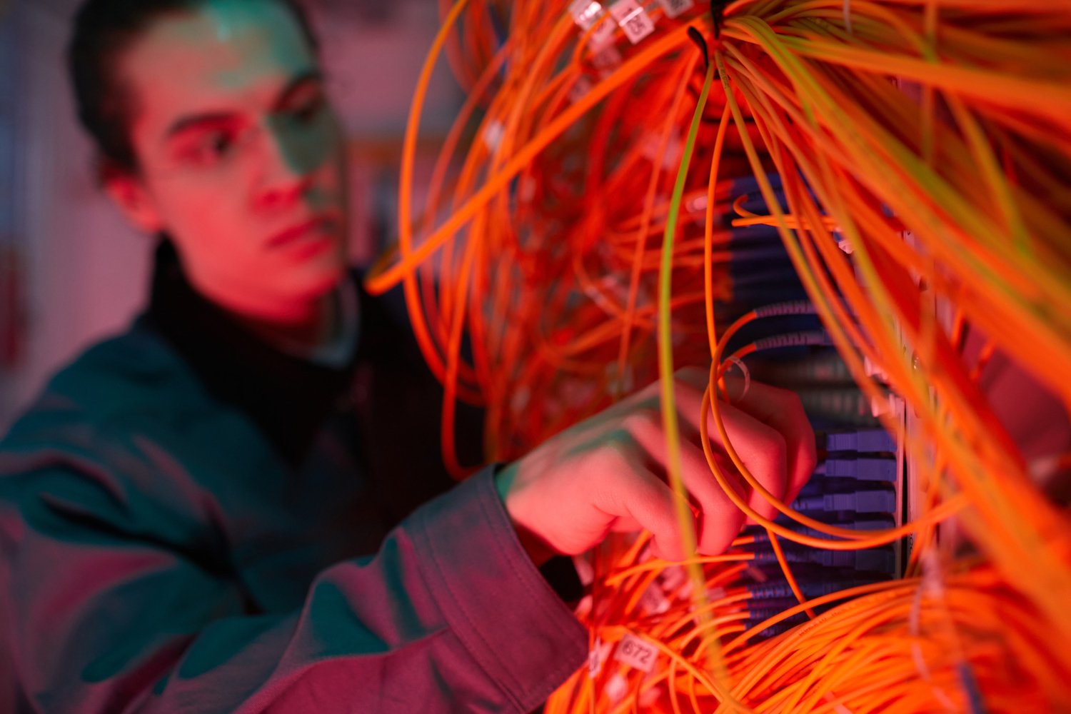 Close up of network technician arranging cables and wires in server room, copy space